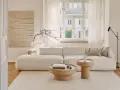 Jasny salon w stylu klasycznym wnętrza. Miękka sofa, drewniane stoliki i subtelna sztuka tworzą przytulną atmosferę.
