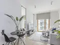 Nowoczesny salon z dużym oknem bez firanek, szarą sofą i czarnym stolikiem. Inspiracje dla okien bez firanek.