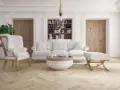 Elegancka sztukateria w nowoczesnym salonie podkreśla jasne meble i drewniane drzwi.