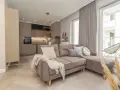 Jak urządzić małe mieszkanie 40 m? Przytulny salon z aneksem kuchennym, wygodna sofa i stylowe dodatki.
