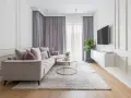 Eleganckie mieszkanie w stylu modern classic z jasną sofą, złotym stolikiem i dekoracyjnymi sztukateriami na ścianach.