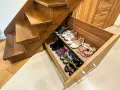 Wnęka pod schodami z wysuwanymi szufladami na buty. Pomysły na przechowywanie obuwia w praktyczny sposób.