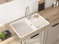 Nowoczesna kuchnia z białym zlewozmywakiem i baterią. Wymiana baterii kuchennej to dobry pomysł na odświeżenie wyglądu.