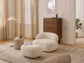 Miękkie meble w kolorze waniliowym tworzą przytulną atmosferę. Wnętrze rozświetlają jasne zasłony i elegancka lampa.