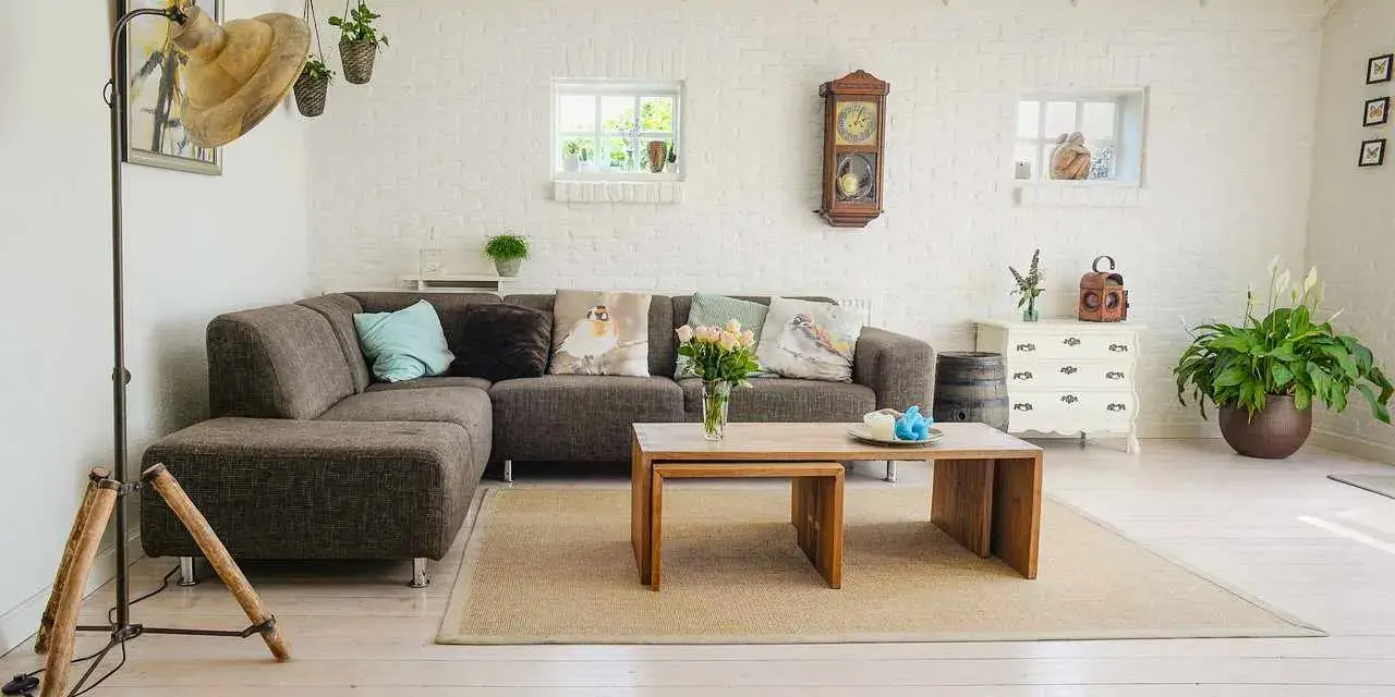 Przytulny salon w stylu feng shui z wygodną kanapą, drewnianymi meblami i dużą ilością zieleni.