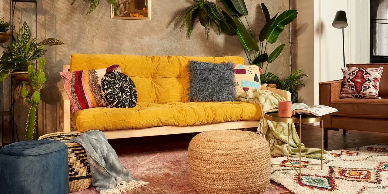 Przytulny salon boho z żółtą kanapą, mnóstwem roślin i etnicznymi dodatkami.
