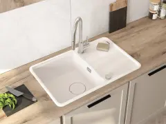 Nowoczesna kuchnia z białym zlewozmywakiem i baterią. Wymiana baterii kuchennej to dobry pomysł na odświeżenie wyglądu.
