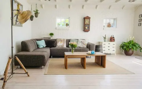 Przytulny salon w stylu feng shui z wygodną kanapą, drewnianymi meblami i dużą ilością zieleni.