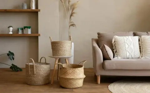 Przytulny salon w stylu boho: plecione kosze, sofa z makramową poduszką i drewniane półki tworzą ciepłą atmosferę.