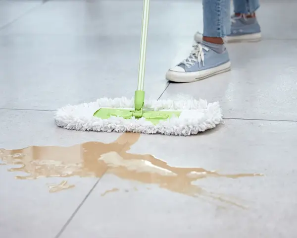 Mop zbiera rozlaną ciecz z gres szkliwiony. Czysta podłoga to podstawa, a odpowiednie środki pomogą utrzymać ją w idealnym stanie.