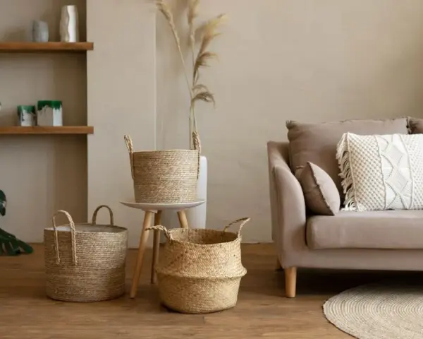 Przytulny salon w stylu boho: plecione kosze, sofa z makramową poduszką i drewniane półki tworzą ciepłą atmosferę.