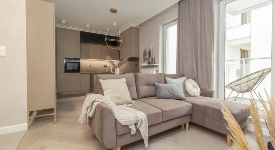 Jak urządzić małe mieszkanie 40 m? Przytulny salon z aneksem kuchennym, wygodna sofa i stylowe dodatki.