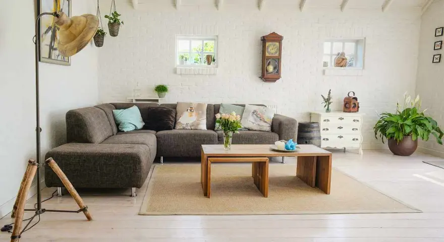 Przytulny salon w stylu feng shui z wygodną kanapą, drewnianymi meblami i dużą ilością zieleni.