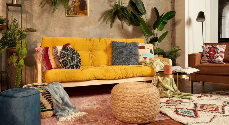 Przytulny salon boho z żółtą kanapą, mnóstwem roślin i etnicznymi dodatkami.
