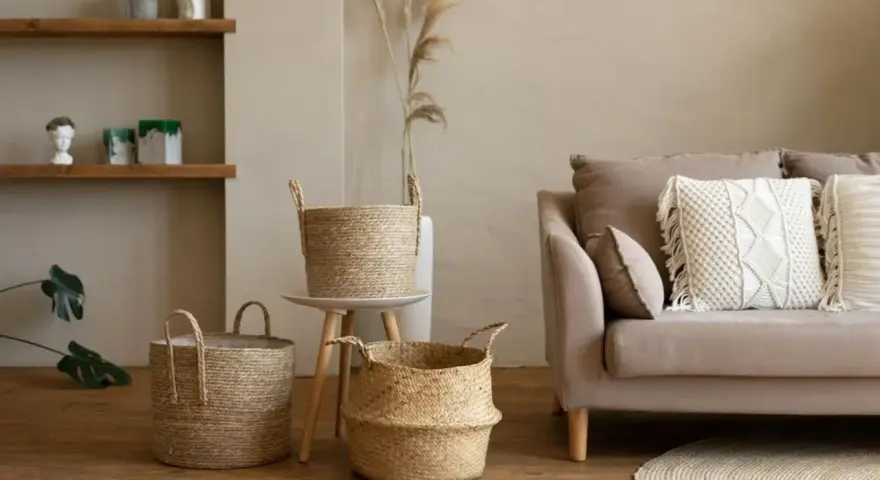 Przytulny salon w stylu boho: plecione kosze, sofa z makramową poduszką i drewniane półki tworzą ciepłą atmosferę.