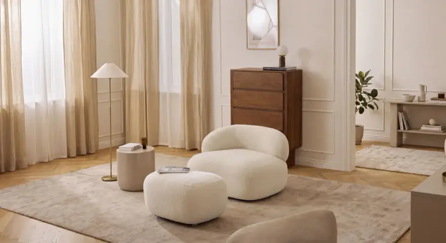 Miękkie meble w kolorze waniliowym tworzą przytulną atmosferę. Wnętrze rozświetlają jasne zasłony i elegancka lampa.