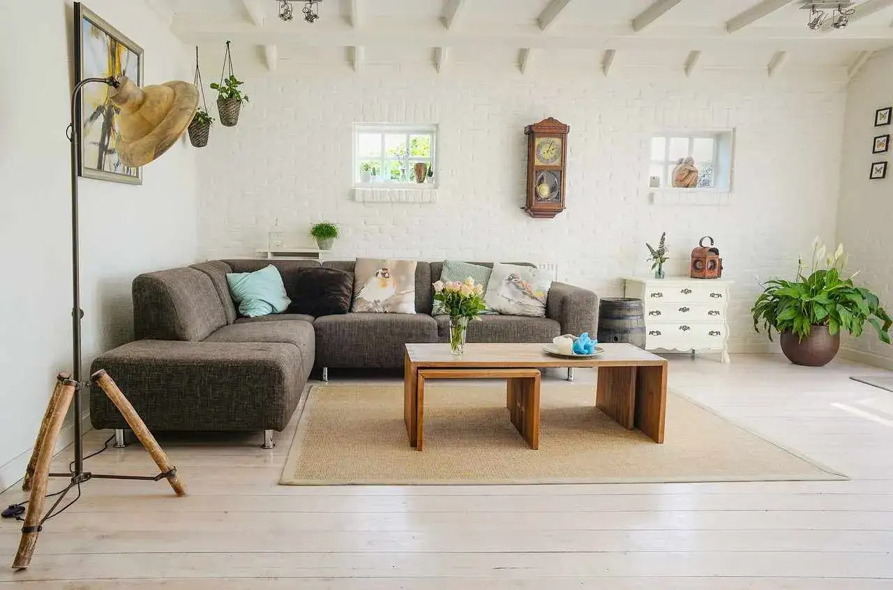 Przytulny salon w stylu feng shui z wygodną kanapą, drewnianymi meblami i mn&oacute;stwem zieleni.